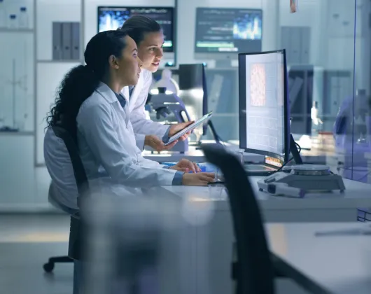 scientists looking at a computer screen in a lab